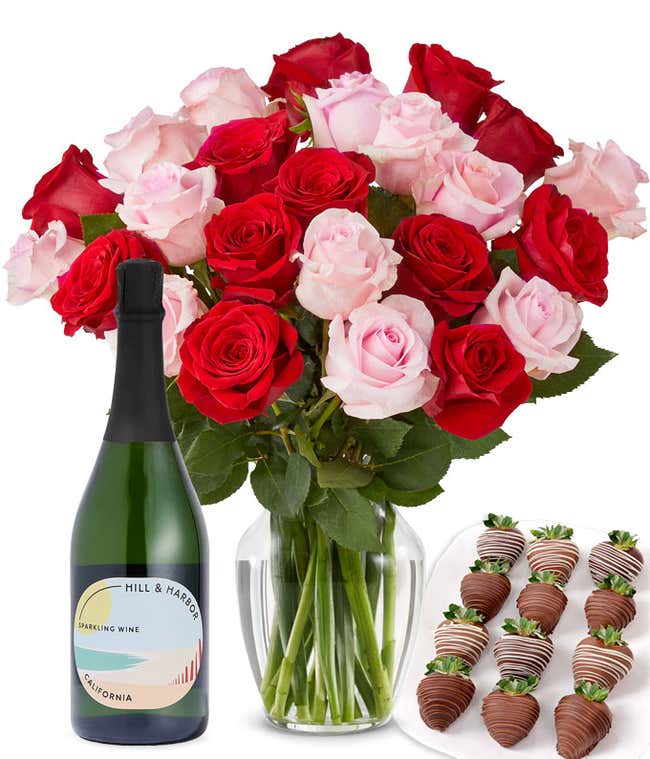 A mixed bouquet of 2 dozen red and blush roses in a clear vase is paired with a bottle of Hill &amp; Harbor Sparkling Wine and 12 chocolate-covered strawberries.